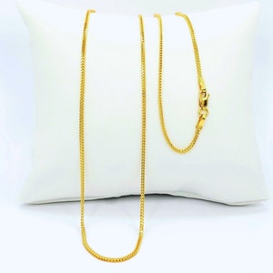 May include: A gold chain necklace with a box clasp. The chain is a delicate, thin design.