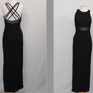 Pode incluir: Um vestido maxi preto com costas de tiras cruzadas e um painel transparente na cintura.