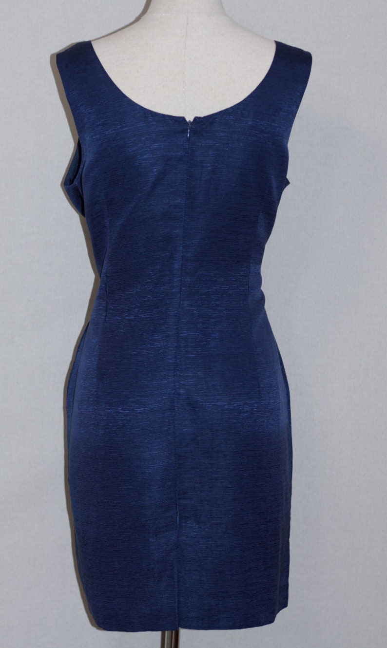 May include: A sleeveless navy blue dress with a scoop neckline and a back zipper closure.