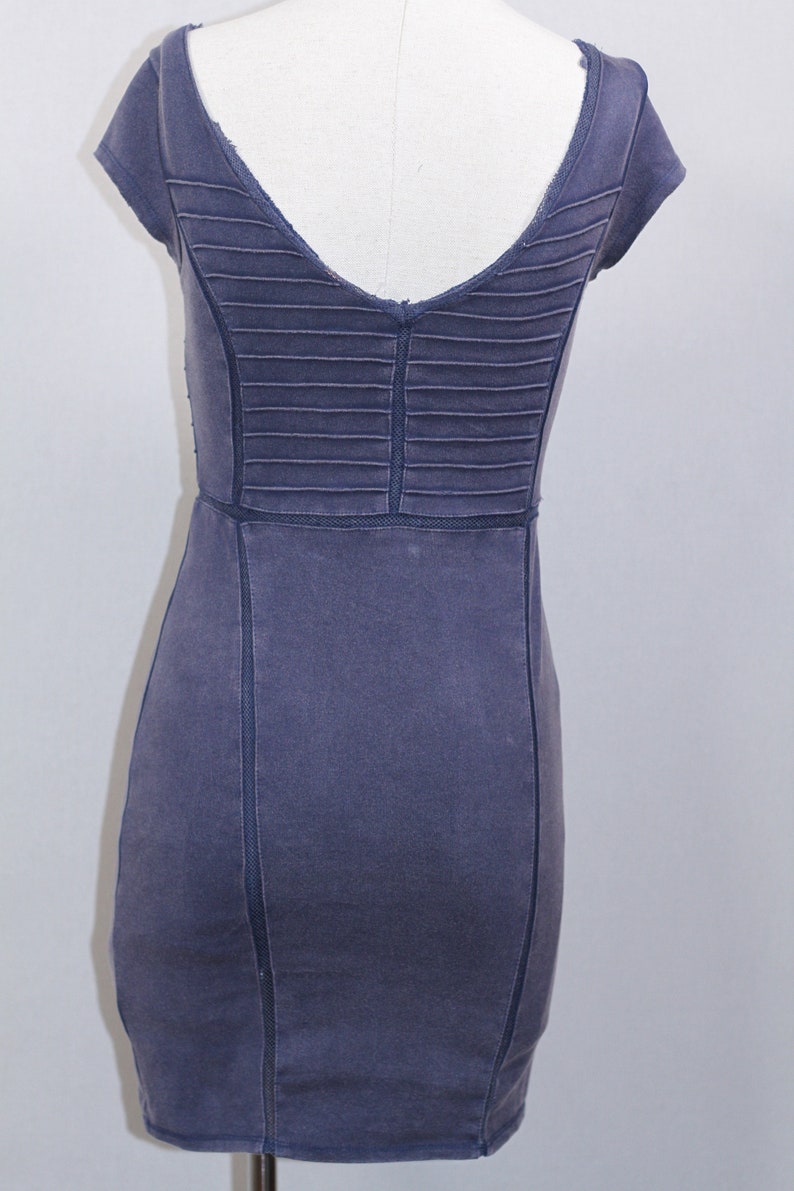 K&ouml;nnte beinhalten: Ein dunkelblaues, kurz&auml;rmeliges Kleid mit V-Ausschnitt und einem plissierten R&uuml;ckenpanel. Das Kleid hat eine figurbetonte Silhouette und einen geraden Saum.