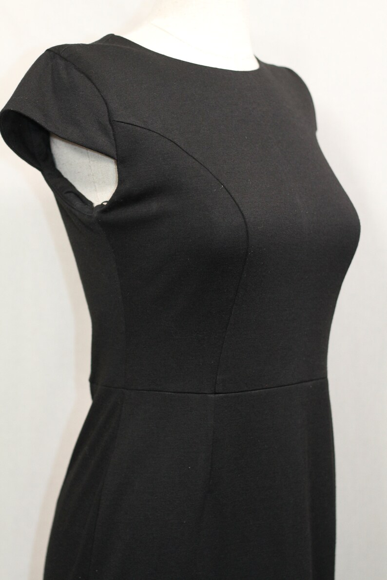 K&ouml;nnte beinhalten: Ein schwarzes &auml;rmelloses Kleid mit Rundhalsausschnitt und figurbetonter Silhouette.