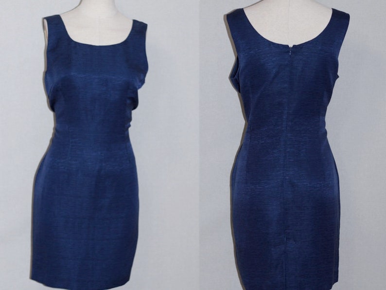 May include: A sleeveless navy blue dress with a fitted silhouette. The dress has a scoop neckline and a back zipper closure.