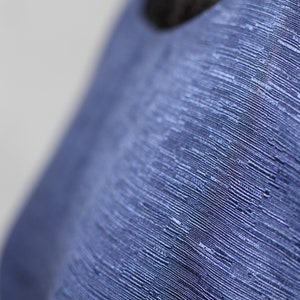 May include: Close-up of a blue fabric with a textured, woven pattern.