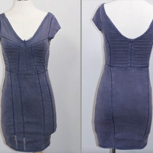 K&ouml;nnte beinhalten: Ein kurzes, figurbetontes, blaues Jeanskleid mit V-Ausschnitt und kurzen &Auml;rmeln. Das Kleid hat ein Korsett-Design mit N&auml;hten.