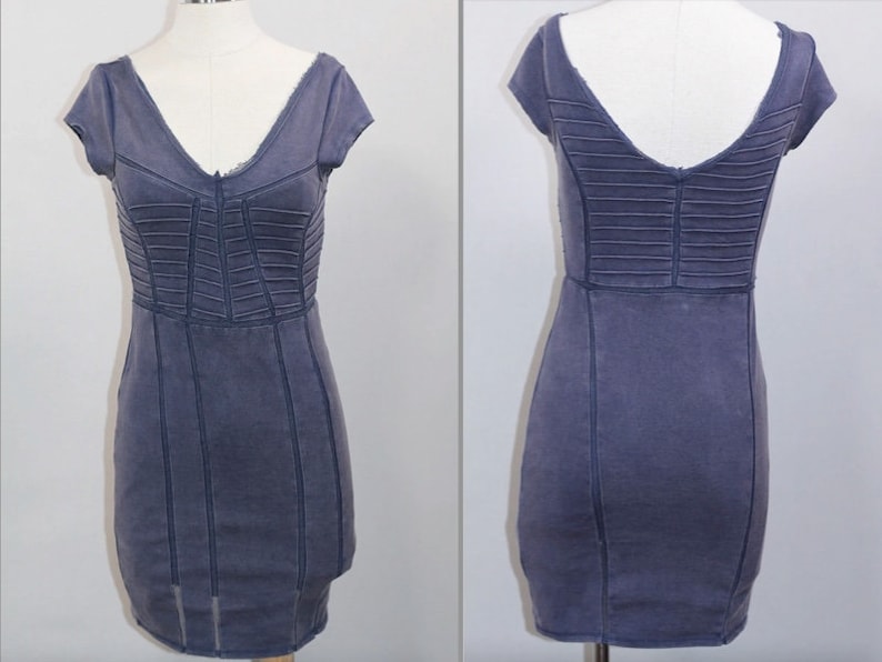 K&ouml;nnte beinhalten: Ein kurzes, figurbetontes, blaues Jeanskleid mit V-Ausschnitt und kurzen &Auml;rmeln. Das Kleid hat ein Korsett-Design mit N&auml;hten.