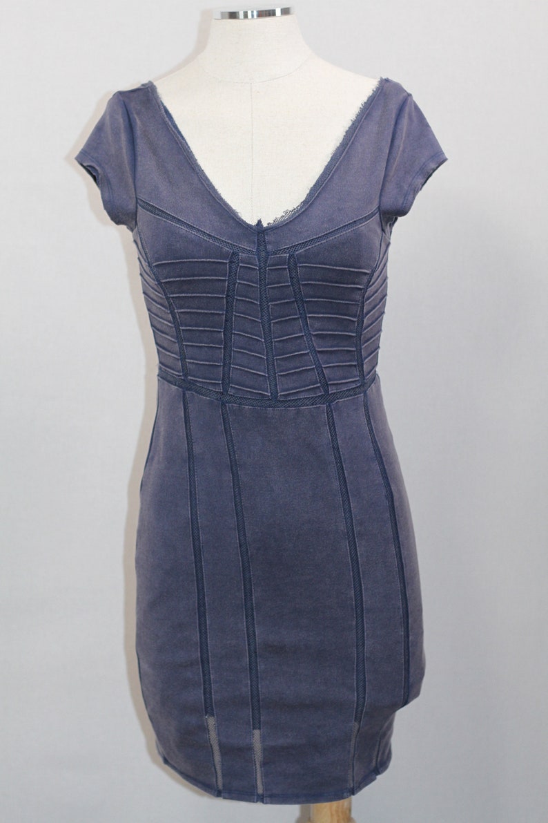 K&ouml;nnte beinhalten: Ein kurz&auml;rmliges, dunkelblaues Kleid mit einem figurbetonten Oberteil und einem leicht ausgestellten Rock. Das Kleid hat einen V-Ausschnitt und ist aus einem strukturierten Stoff gefertigt.