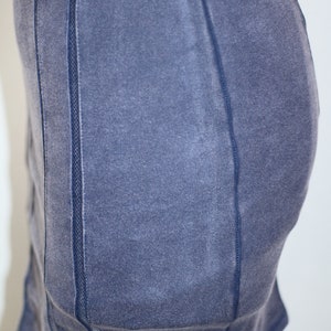 K&ouml;nnte beinhalten: Ein dunkelblaues, figurbetontes Kleid mit einem Mesh-Paneel-Detail an den Seiten. Das Kleid hat einen leicht abgenutzten Look.