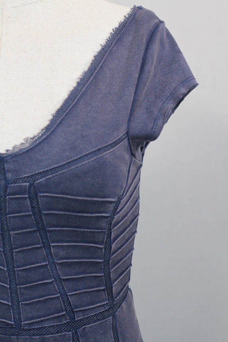 K&ouml;nnte beinhalten: Ein dunkelblaues Kleid mit Spitzenbesatz und einem figurbetonten Oberteil. Das Kleid hat einen V-Ausschnitt und kurze &Auml;rmel.