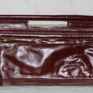 Cartera de mano de piel color burdeos y rojo