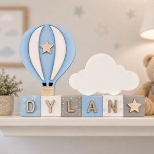 Decoración infantil con globos aerostáticos y bloques personalizados con el nombre del bebé.