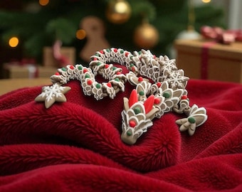 May include: A gingerbread dragon with white icing, red and green accents, and snowflake details rests on a plush red blanket. The festive treat is set against a blurred background of a Christmas tree with ornaments.