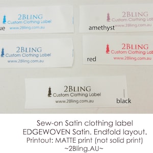 May include: Five white satin clothing labels with the text "2BLING Custom Clothing Label www.2Bling.com.au" printed in different colours. The colours are blue, navy, amethyst, red, and black.