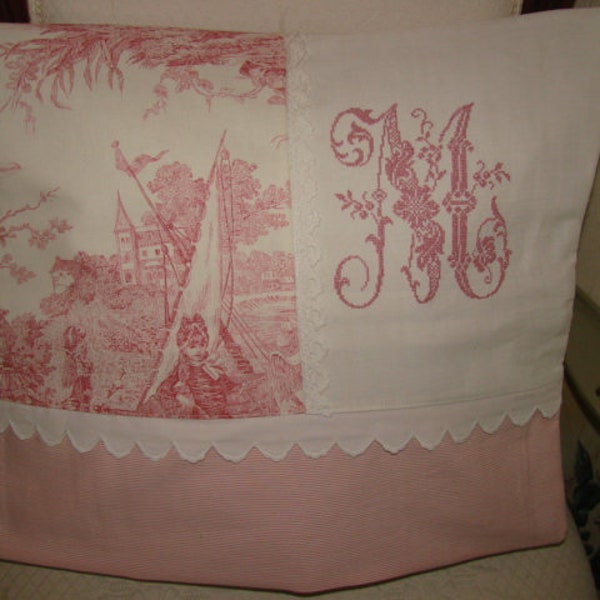 Coussin toile de Jouy rose "Jeux d'eau" avec monogramme **M** brodé au point de croix sur linge ancien.