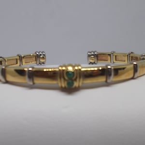 Rigid half round 18kt gold bracelet with two small emeralds. Vintage bracelet