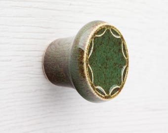 Keramische knop voor meubel nr. 5, donkergroen met bruine spikkels.