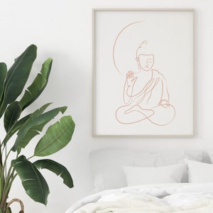 Puede incluir: Un dibujo de l&iacute;nea minimalista de un Buda meditando en color melocot&oacute;n, enmarcado en un marco de madera claro contra una pared blanca.