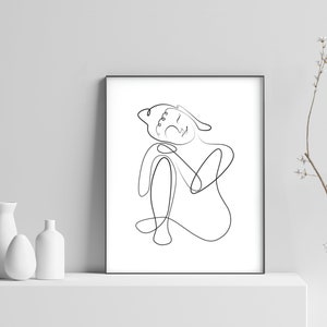 May include: A black and white line drawing of a person sitting with their head resting on their hand. The drawing is in a simple, minimalist style.