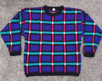 May include: A vintage crew neck jumper with a geometric pattern. The jumper features a grid design with blue, teal, pink, and white blocks on a purple background. The collar and cuffs are black.