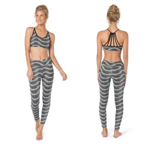 Op de afbeelding: Een zwarte en witte gepatroneerde sportbeha en leggings set. De beha heeft een racerback-stijl en de leggings hebben een hoge taille.