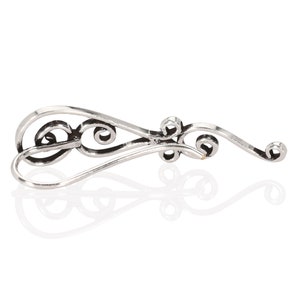 May include: Silver filigree earring with a delicate, curved design. The earring has a hook closure.
