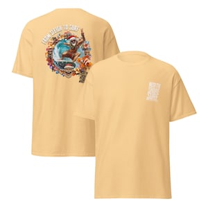 May include: A light yellow t-shirt featuring a graphic of Santa surfing with a fish and the text "From Sleigh to Surf" on the back. The front of the shirt has the text "North Shore Surf".