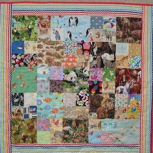 May include: A colorful patchwork quilt with a variety of animal and nature-themed fabric squares. The quilt is bordered with a multi-colored, scalloped trim.