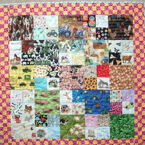 May include: A colorful patchwork quilt with a pink and yellow checkered border. The quilt is made up of various squares of fabric featuring farm animals, tractors, and other rural themes.
