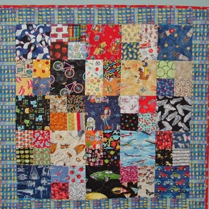 May include: A colorful patchwork quilt with a variety of patterns, including bowling pins, cars, and stars. The quilt is made up of many different squares, each with a unique design. The quilt is bordered with a blue and white striped fabric.