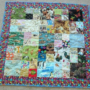 May include: A colorful patchwork quilt featuring various animal prints, including lions, giraffes, and penguins. The quilt has a vibrant border with a polka dot pattern in multiple colors. The quilt is square-shaped.
