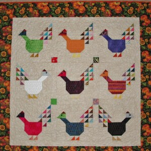 May include: A patchwork quilt with a beige background and a border of orange, green, and brown. The quilt features eight colorful patchwork chickens with different patterns and colors.