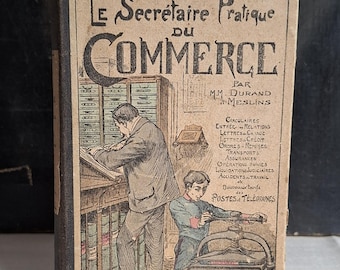 May include: Antique French book titled "Le Secrétaire Pratique du Commerce" with illustrations of people working. The cover is tan with black and red text and illustrations. The book is bound with a dark spine.