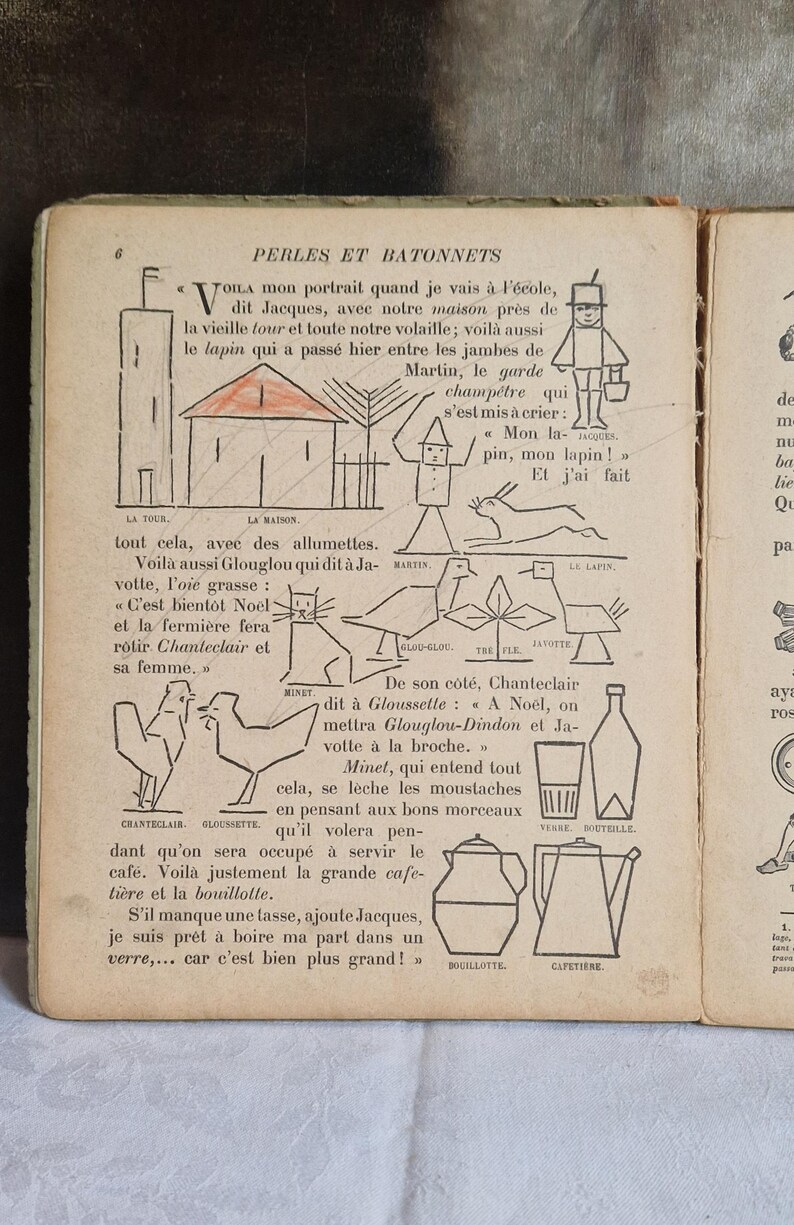 May include: Vintage children's book page with illustrations and French text. The page features drawings of a house, tower, animals, and a person. The text is in black ink, and some elements are colored in red.