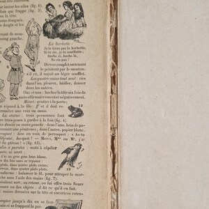 May include: Open book with aged pages featuring illustrations and French text. The left page has drawings of people and animals, with text in a vintage font. The right page is blank.