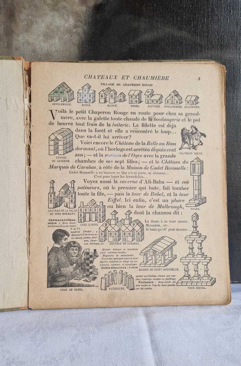 May include: An open book page with illustrations and French text. The page features drawings of buildings, people, and scenes from a story, including a castle and a tower. The text is in black ink.