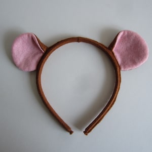 May include: Brown headband with pink felt ears. The headband is made of a soft, flexible material and is perfect for dressing up as a bear.