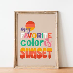 May include: Framed art print with the text "my FAVORITE color is SUNSET" in colorful, bold letters. A stylized sunset graphic is at the top. The print is in a wooden frame.