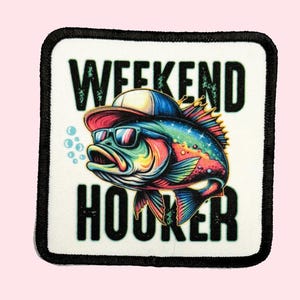 May include: A white square patch with black trim features a colorful cartoon fish wearing sunglasses and a baseball cap. The text "Weekend Hooker" is printed in black letters.