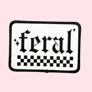 May include: White patch with black border and black text that reads "*feral*" in a gothic font.  A black and white checkered pattern is below the text.