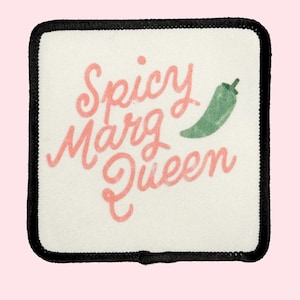 May include: A white square patch with black stitching around the edges. The patch has a pink and green illustration of a chili pepper and the text "Spicy Marg Queen".