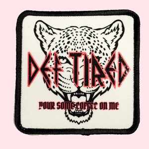 May include: White square patch with black border. A black and white cheetah head with red text that says "DE-TIRED" and "POUR SOME COFFEE ON ME".