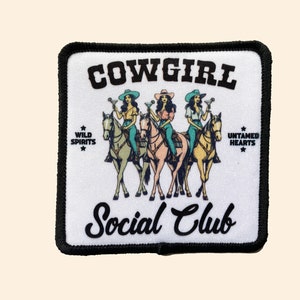 May include: Square patch with a black border featuring the text "COWGIRL Social Club." The design includes three women riding horses, each holding a cocktail. The words "Wild Spirits" and "Untamed Hearts" are also present.