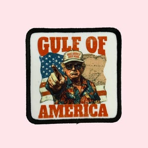 May include: A white patch with black edging features a cartoon image of a man wearing a red, white, and blue baseball cap with the text "Make America Great Again". He is pointing with his right hand and wearing a colorful shirt. The text "Gulf of America" is in red letters at the top of the patch and the text "America" is in red letters at the bottom of the patch.