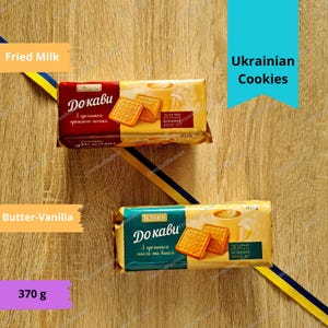 May include: Two packages of Roshen Do Kavi cookies. The top package is labeled "Fried Milk" and contains 153 grams. The bottom package is labeled "Butter-Vanilla" and contains 370 grams. Both packages feature a yellow and blue background with the text "Ukrainian Cookies" in a blue box.