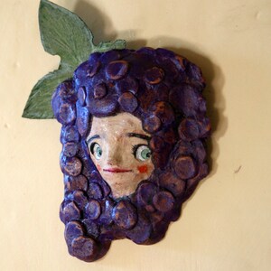 Grappolo d'uva,vigne toscane,terracotta da appendere,sculturina da parete,figurina dipinta,volto che spunta dal grappolo d'uva,uva toscana