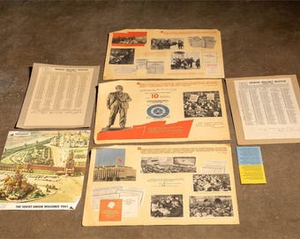 May include: A collection of vintage propaganda posters and documents, featuring images of historical events, architectural landmarks, and portraits. The posters are in various sizes and colors, with text in a foreign language. The text "The Soviet Union Welcomes You!" is visible.