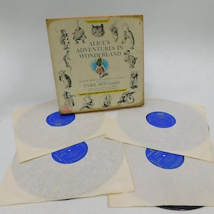 May include: A vintage record set of Alice's Adventures in Wonderland by Lewis Carroll, narrated by Cyril Ritchard. The set includes four records, a box with illustrations of characters from the book, and a booklet.