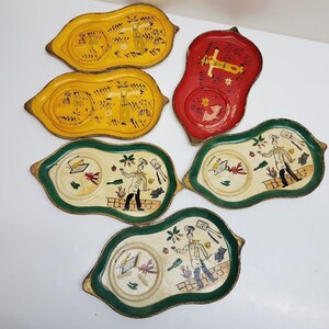 May include: Set of ten vintage ceramic coasters with hand-painted designs. Each coaster features a different scene with a chef, a scarecrow, and other whimsical characters. The coasters are in various colors, including red, yellow, and green.
