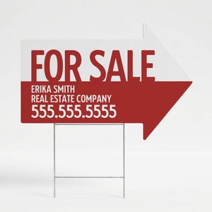 May include: A directional arrow-shaped real estate yard sign with a white top half and red bottom half. The text reads FOR SALE, ERIKA SMITH, REAL ESTATE COMPANY, and 555.555.5555. The sign is supported by a thin silver metal wire H-frame stand.