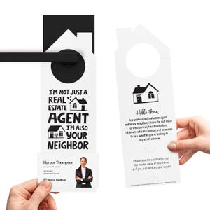 a person holding a door hanger with a picture of a house on it