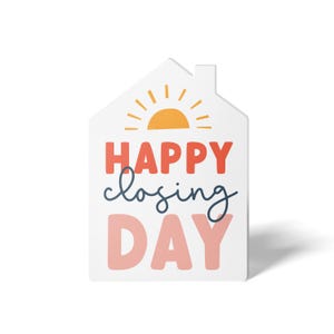 May include: White house-shaped sign with a yellow sun and the text "HAPPY closing DAY" in pink, red, and blue.